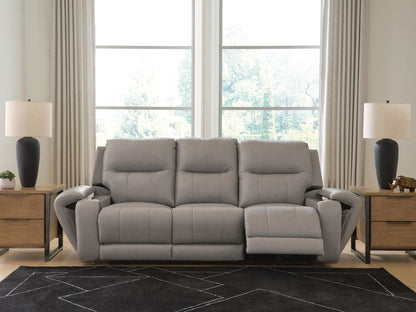 Real Moments power reclining sofa in ash gray leather with plush segmented cushions, wide arms and an extended footrest