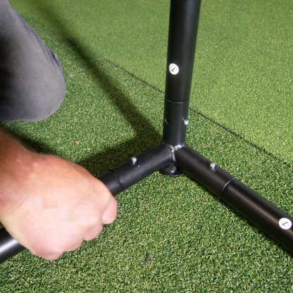 SimBox Golf Simulator Enclosure features black tubular frame connectors being assembled on green artificial turf