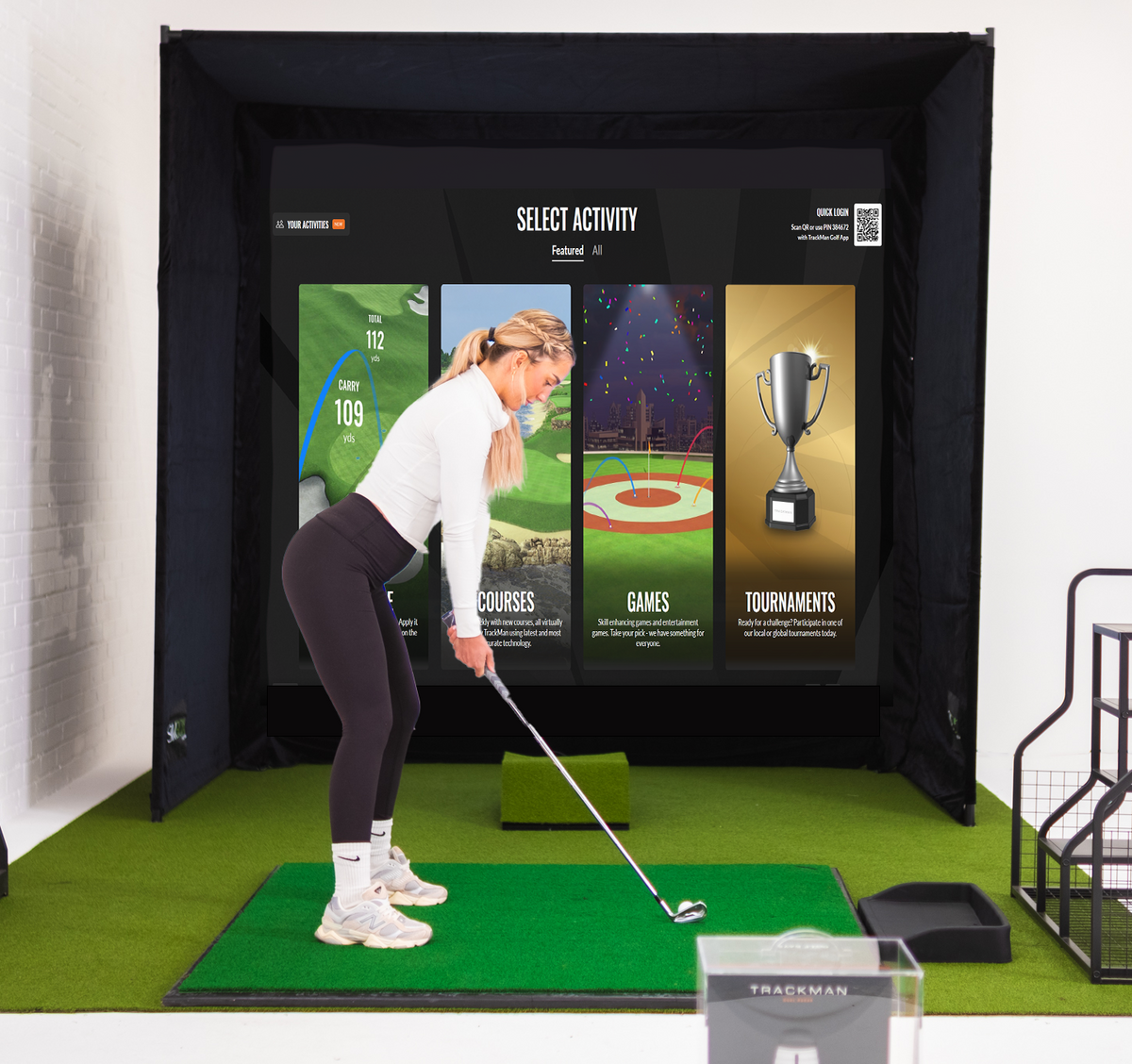 SimBox Golf Simulator Enclosure with a black fabric frame, digital golf screen, and green turf hitting mat