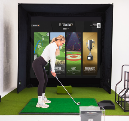SimBox Golf Simulator Enclosure with a black fabric frame, digital golf screen, and green turf hitting mat