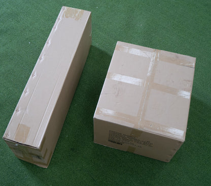 SimBox Golf Simulator Enclosure packed in two taped cardboard shipping boxes, one long narrow carton and one square box